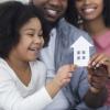 Black Family Holding Cutout Paper House In Hands